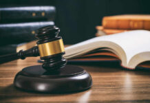 Judge's gavel on desk with open law book
