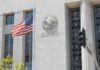 United States courthouse facade with American flag at half-mast