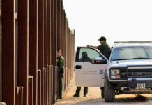 Trump Locks Multi-Year Crackdown Cash U.S. Customs and Border Protection officers near a border fence