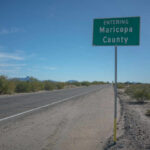 Road sign indicating entry into Maricopa County with a clear blue sky