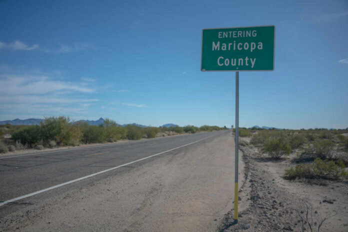 Road sign indicating entry into Maricopa County with a clear blue sky