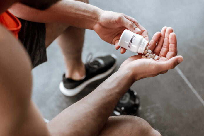 Person pouring probiotic pills into their hand