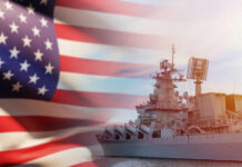 A naval ship with the American flag in the foreground
