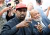 A man wearing a red cap gestures during a discussion at a political event