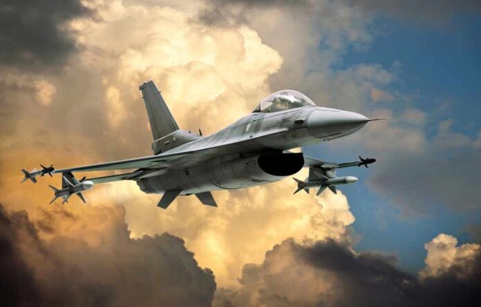 A fighter jet flying through a dramatic cloudy sky