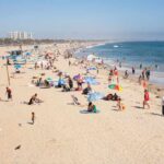 Crowded beach with people sunbathing and playing in the water