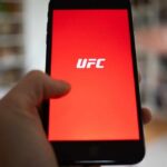 Hand holding smartphone with red app screen