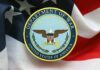 Pentagon Rename Sparks Cost Fight Emblem of the Department of War on a background of the American flag