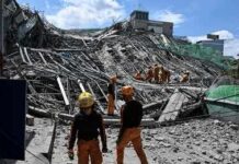 Rescue workers search a collapsed building site