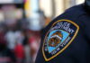Media Myth Explodes In Harlem Close-up of a New York City police badge on a uniform