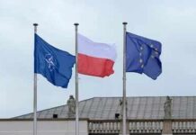 Three flags on poles including NATO, Poland, and the European Union