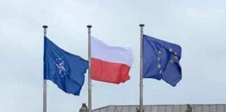 Three flags on poles including NATO, Poland, and the European Union