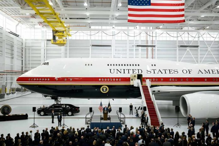 Presidential aircraft in a hangar with a podium and crowd below