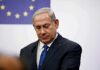 ICC Twist: NYC Mayor Targets Netanyahu man in suit at podium with EU flag in background