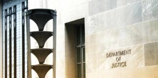 Department of Justice building exterior with sign and metal sculpture