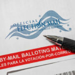 Official election mail envelope with a pen resting on it
