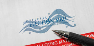 Official election mail envelope with a pen resting on it
