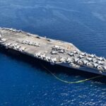 Navy Scraps Space-Skimming Fighter—Why? An aircraft carrier with numerous fighter jets on its deck in the ocean