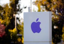 Purple Apple logo on a white sign in an outdoor setting
