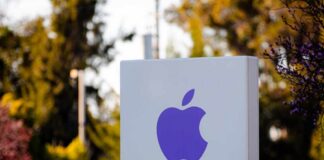 Purple Apple logo on a white sign in an outdoor setting