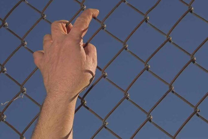 shutterstock_10213060 Hand gripping a chain-link fence