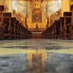 Church interior with wooden pews facing ornate altar