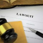Lawsuit documents with gavel, pen, and legal book