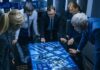 Team of professionals analyzing digital map on interactive table