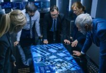 AI Smear Machine Hits Top French Contenders Team of professionals analyzing digital map on interactive table