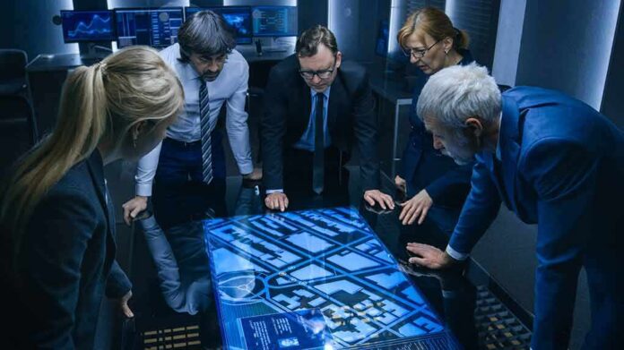 Team of professionals analyzing digital map on interactive table