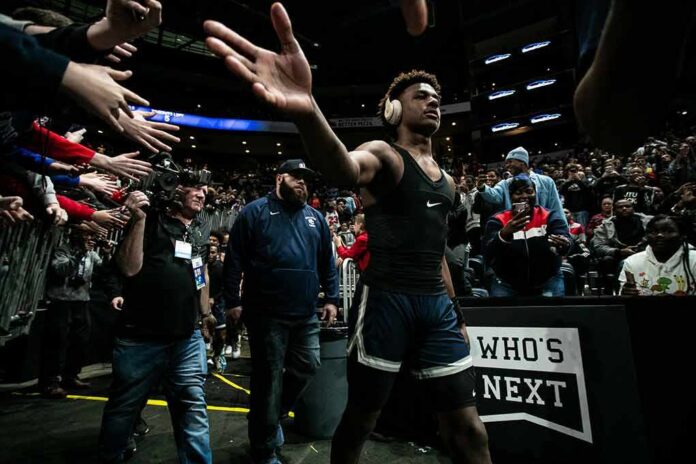 Basketball player in headphones high-fives fans while walking past crowd