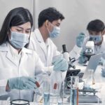 Regulators Stunned: Bacteria Muzzle Uranium Scientists in lab coats working with test tubes and microscopes