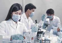 Regulators Stunned: Bacteria Muzzle Uranium Scientists in lab coats working with test tubes and microscopes