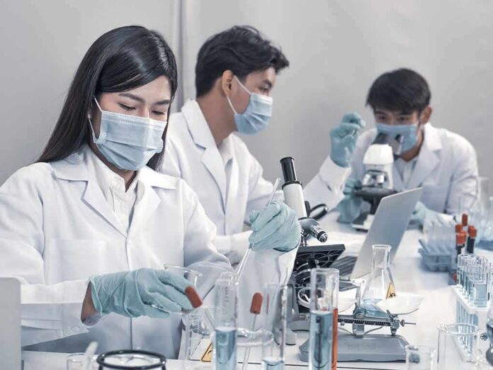Scientists in lab coats working with test tubes and microscopes