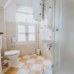 Luxury? Berlin Bans Extra Bathrooms Small tiled bathroom with toilet, sink, and shower