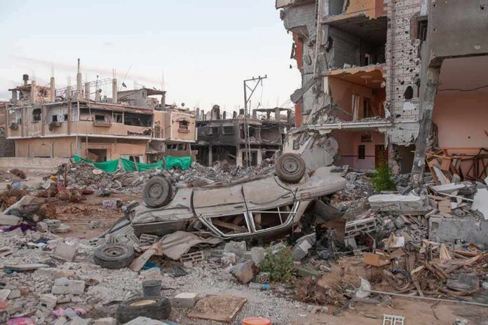 Overturned car amid rubble and heavily damaged buildings