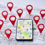 Smartphone with map app surrounded by red location pins