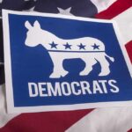 Democrats donkey symbol on a blue sign over an American flag