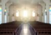 Empty church interior with sunlight at the altar