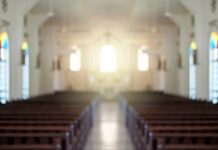 Empty church interior with sunlight at the altar