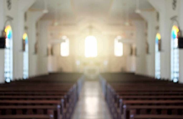 Empty church interior with sunlight at the altar