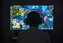 Gamer wearing headphones facing a large screen