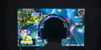 Gamer wearing headphones facing a large screen