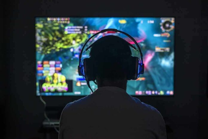 Gamer wearing headphones facing a large screen