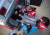 Paramedics load a patient on a stretcher into an ambulance