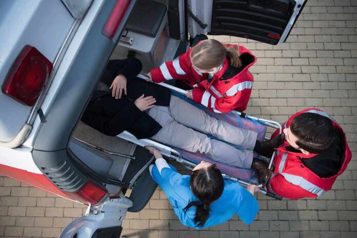 Paramedics load a patient on a stretcher into an ambulance