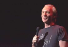 comedian holding a microphone on stage