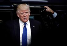 Donald Trump stepping out of a vehicle in a suit and blue tie