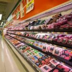 Grocery store meat aisle stocked with packaged beef and poultry