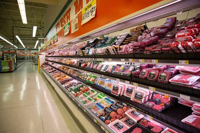 Grocery store meat aisle stocked with packaged beef and poultry